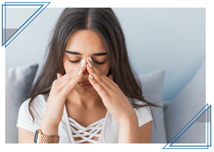 woman holding her nose in pain