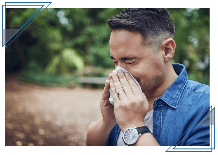 man blowing his nose into tissue