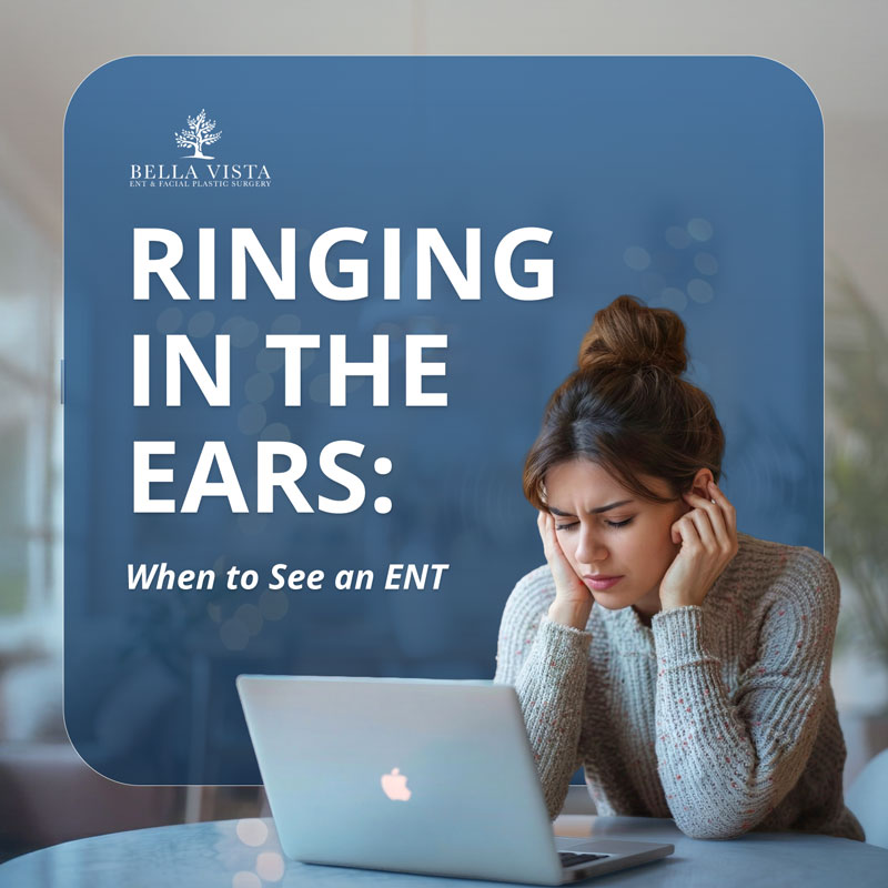 Person covering ears while using a laptop