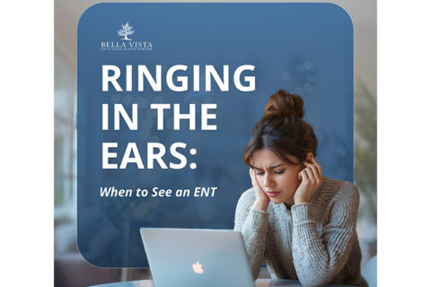 Person covering ears while using a laptop